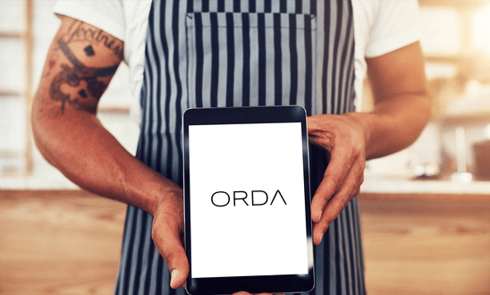 Gastronom hält Tablet und nutz das ORDA Bestellsystem für Gastronomie by GastroSoft